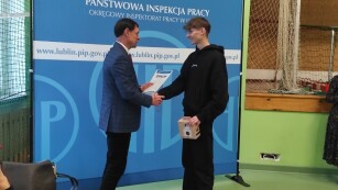 Rafał Nowakowski otrzymuje dyplom oraz nagrodę od Inspektora PIP